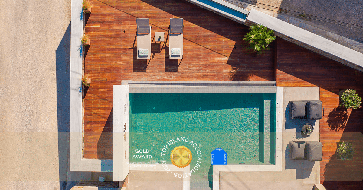 Aerial photo of a private swimming pool of a luxury villa in Tinos, with a gold award logo "Top Island Accommodation 2023 - Greece Stay Awards"